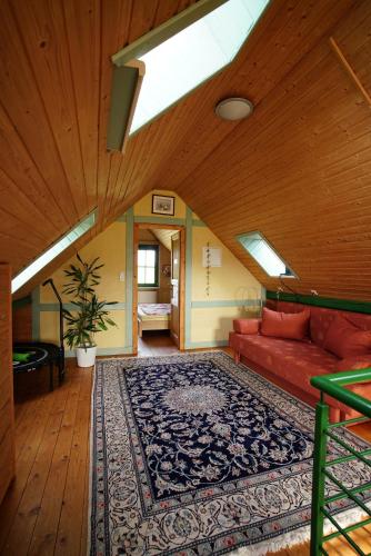 a living room with a red couch and a rug at Ferienwohnung Dina in Olbernhau