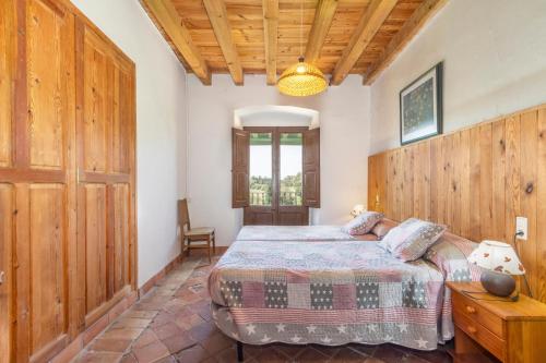a bedroom with a bed and a wooden wall at El Torrent in Pinell de Solsones
