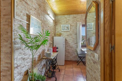 a hallway with a brick wall and a refrigerator at Casa Rosi Cave House in Artenara