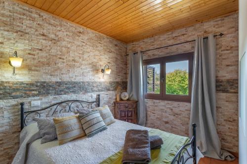 a bedroom with a bed and a brick wall at Casa Rosi Cave House in Artenara