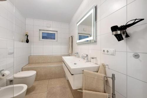 a white bathroom with a sink and a toilet at Ferienwohnung Talblick in Stockach
