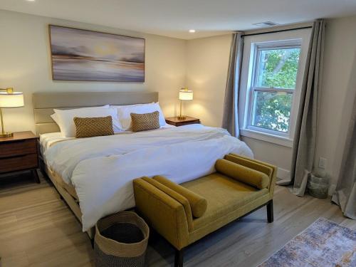 a bedroom with a large bed with a chair and a window at Modern Comfort in Marlborough