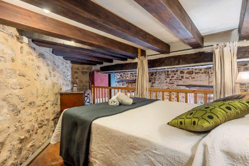 a bedroom with a bed and a stone wall at Ca La Germandat Paüls in Paúls