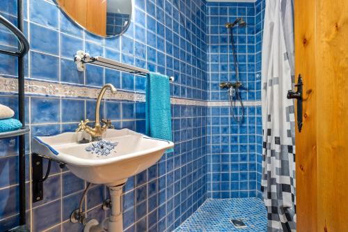 a blue tiled bathroom with a sink and a shower at Ca La Germandat Paüls in Paúls
