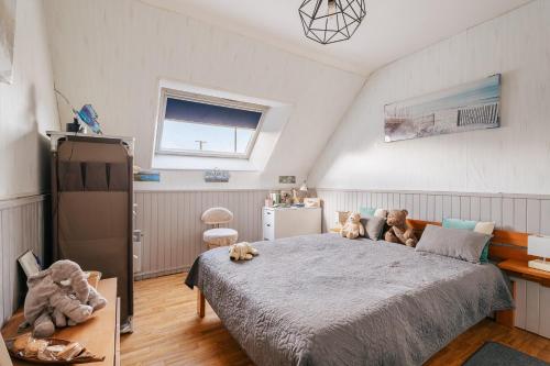 a bedroom with a bed with stuffed animals on it at Les chambres de Florence in Saint-Jouan-de-lʼIsle