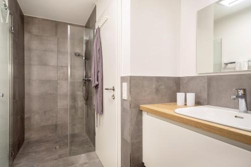 a bathroom with a sink and a shower at Ländle Lodge bei Bregenz in Langen bei Bregenz