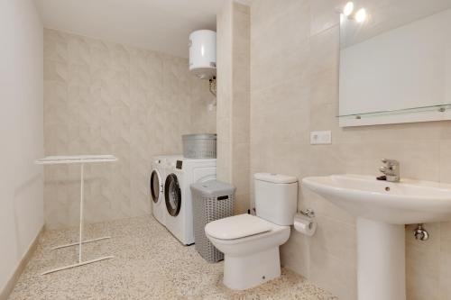 a white bathroom with a toilet and a sink at Edificio El Baifo Loco - Milena in Gran Tarajal