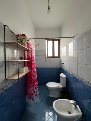 a blue and white bathroom with a toilet and a sink at 3 Roots Villa in Krujë