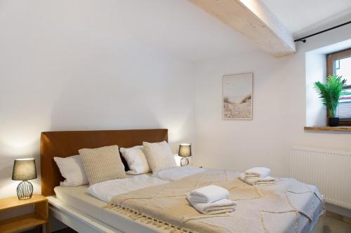 a white bedroom with a bed with towels on it at Felicitas in Tann