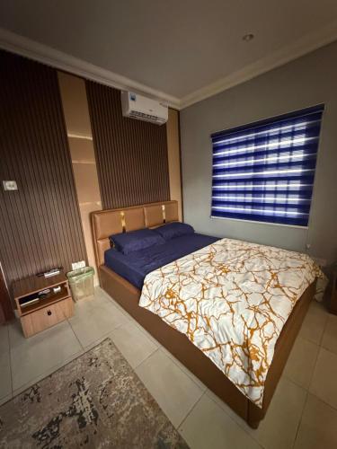 a bedroom with a bed and a large window at Max Court in Ikeja