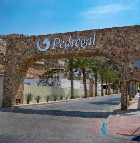 a stone archway with the sign for a paredical sign at Casa del Vistas Pedregal in Cabo San Lucas