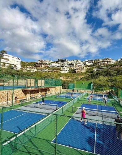 a group of people playing tennis on tennis courts at Casa del Vistas Pedregal in Cabo San Lucas