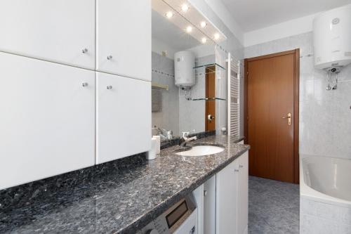 a white bathroom with two sinks and a mirror at Apartment Bossi View in Chiavenna