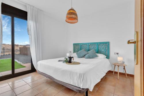 a bedroom with a bed and a large window at Villa Asensio in Lajares