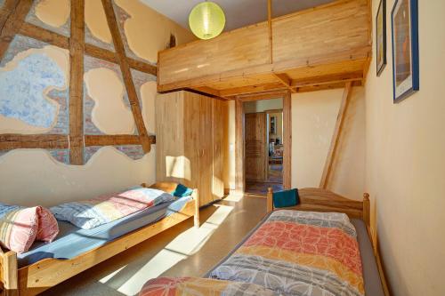 two beds in a room with wooden walls at Gutshaus Meerzauber in Altenkirchen