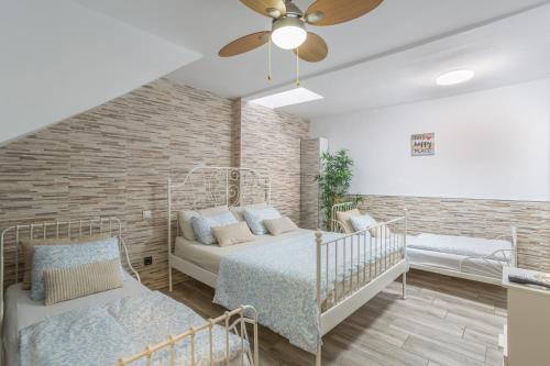 a bedroom with two beds and a brick wall at Welcome To The Relax Zone in Los Caideros