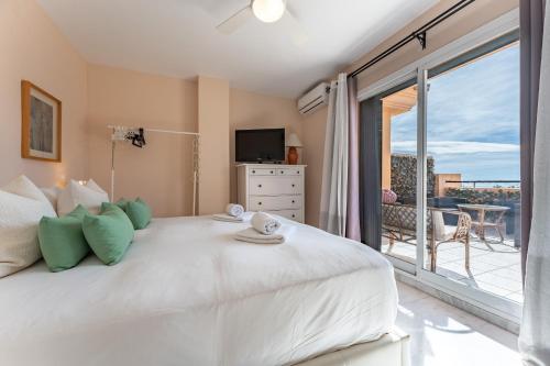 a bedroom with a large white bed and a balcony at Penthouse 3-bedroom duplex in Mijas