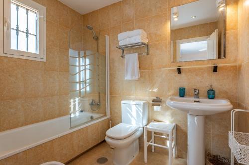 a bathroom with a toilet and a sink and a shower at Penthouse 3-bedroom duplex in Mijas