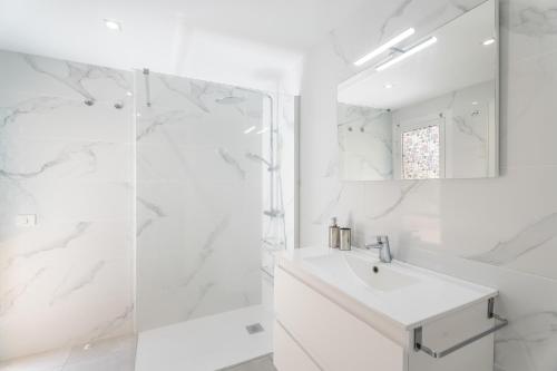 a white bathroom with a sink and a shower at Apartamento Afirama 1 in Araya