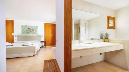 a bathroom with two sinks and a bed at Son Aladern in Islas Baleares