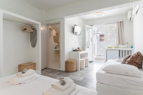 a white room with three beds and a bathroom at A Tinian Room 4 in Tinos