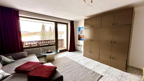 a living room with a couch and a large window at Ferienpark Oberallgäu Haus 1 in Missen-Wilhams