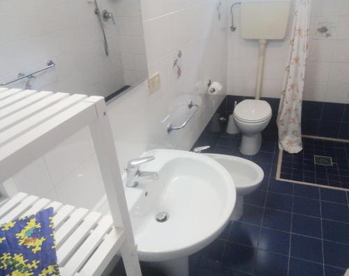 a bathroom with a white sink and a toilet at Euroholiday Village 3G in Lido di Jesolo