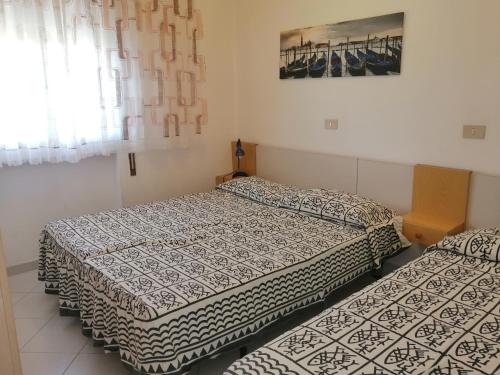 two beds sitting in a room with at Euroholiday Village 3G in Lido di Jesolo