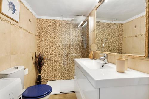 a bathroom with a white sink and a toilet at Plus Romance in Puerto del Carmen