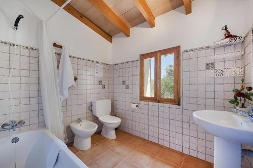 a bathroom with two toilets and a tub and a sink at Las Palmeras in El Port