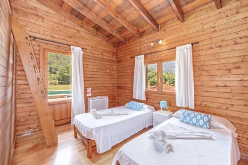 a bedroom with two beds in a log cabin at Finca L'hort Nou in Pollença