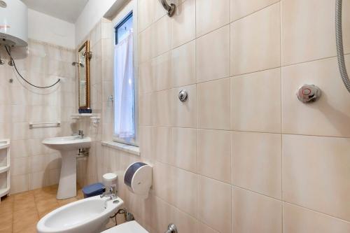 a white bathroom with a sink and a toilet at Sciabattica - Lacona in Lacona