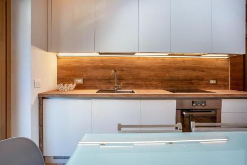 a kitchen with white cabinets and a sink at Condominio Lucia 12 Pinzolo in Pinzolo