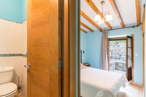 a bathroom with a bed and a toilet in a room at Casa Rural El Agero in Cabañes