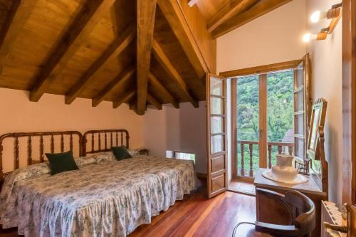 a bedroom with a bed and a large window at Casa Rural El Agero in Cabañes