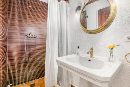 a bathroom with a sink and a shower with a mirror at Ca la Pasita 26 in Beniali