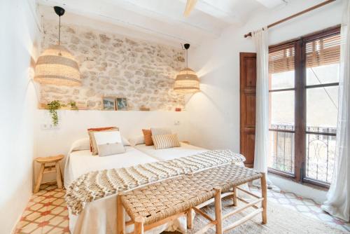 a bedroom with a bed and a stone wall at Ca la Pasita 26 in Beniali