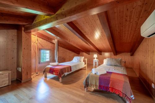 two beds in a room with wooden ceilings at Son San Marti Gran in Can Picafort