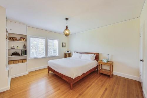 a white bedroom with a bed and a wooden floor at Spacious 2br Near Ocean & Sutro Heights Park in San Francisco