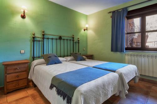 two beds in a room with green walls at Aldaron in Boca de Huérgano