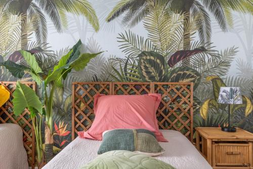 a bedroom with a bed with a tropical wallpaper at Gite Du Ptit Lou in Noyers-sur-Cher