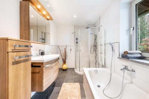 a bathroom with a tub and a sink and a shower at Ferienwohnung am Silberberg in Bodenmais