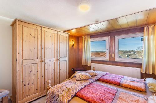 a bedroom with a bed and two windows at Casa Felicitas Fewo und Studio in Möhnesee