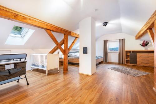 an attic bedroom with a bed and wooden beams at Ferienwohnung am Silberberg in Bodenmais