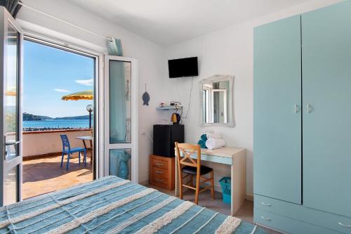 a bedroom with a bed and a desk with a view of the ocean at Sciabattica - Lacona in Lacona