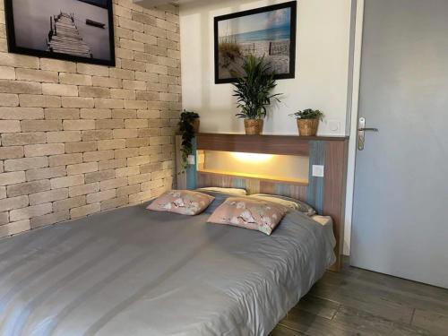 a bed in a room with a brick wall at La Noisette in Équemauville