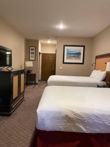 a hotel room with two beds and a flat screen tv at Wagon Wheel Yellowstone in West Yellowstone
