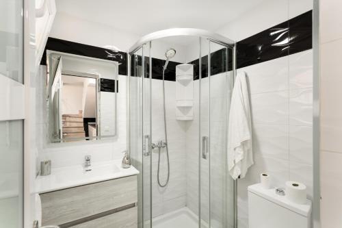 a white bathroom with a shower and a sink at Exclusive Sonemar in Maspalomas