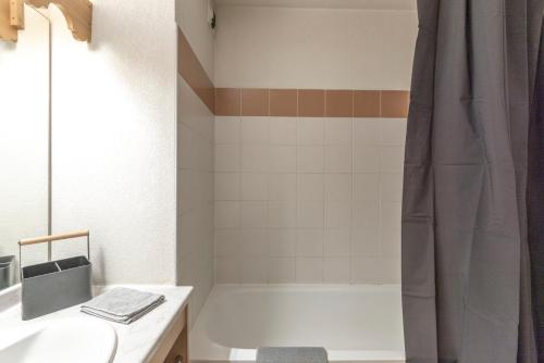 a bathroom with a white tub and a shower at Appartement à Samoëns – 6 couchages in Samoëns