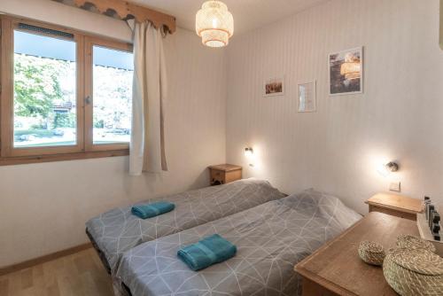 a bedroom with two beds and a window at Appartement à Samoëns – 6 couchages in Samoëns